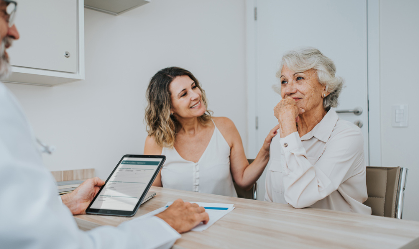 Older woman and her daughter attend a palliative care meeting with a palliative care clinician