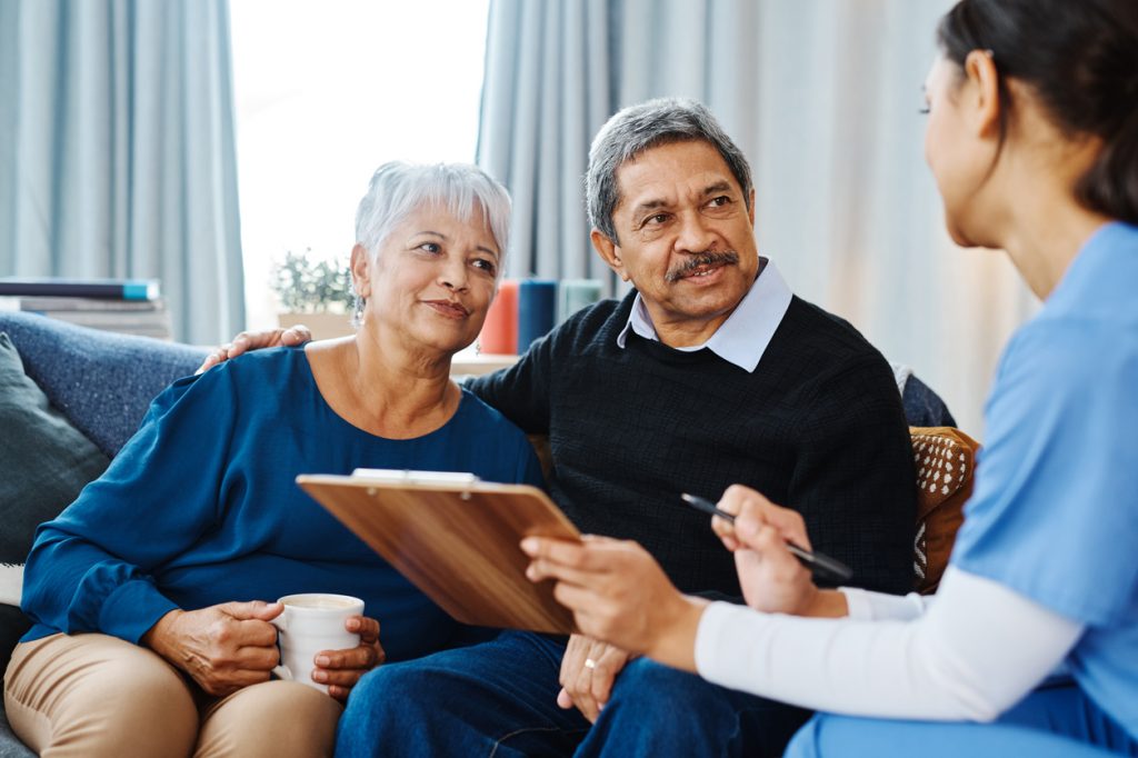 Patient with serious illness sitting with loved one and a palliative care doctor