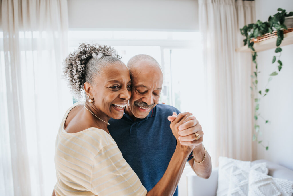 Happy couple dancing together in their home