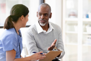 Person living with serious illness talks to nurse about assessment tool